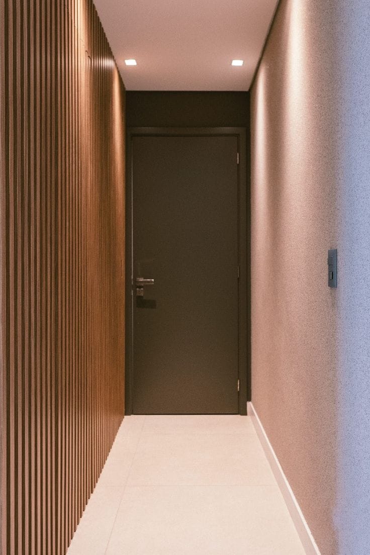 Corredor com porta mimetizada e espelho redondo decorativo — Forlan Interiores