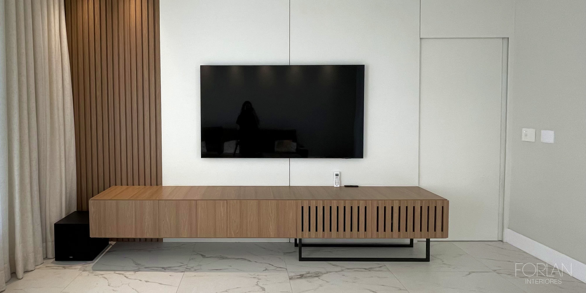 Sala com painel circular iluminado e TV — Forlan Interiores